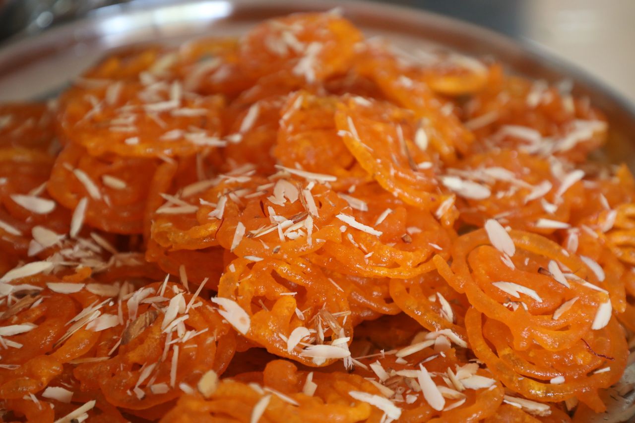 Delicious jalebi dessert topped with almond slices, perfect for festive occasions and celebrations.